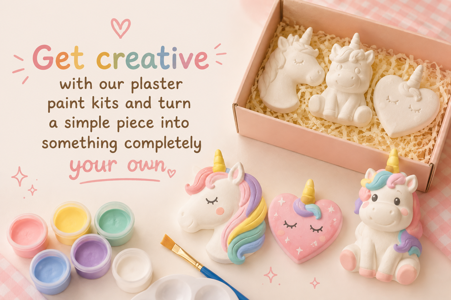 A pastel-themed craft kit display with unpainted white unicorn and heart shapes in a pink box, plus painted examples in pink, purple, yellow, and rainbow colors. Text on the left reads, 'Get creative with our plaster paint kits and turn a simple piece into something completely your own.